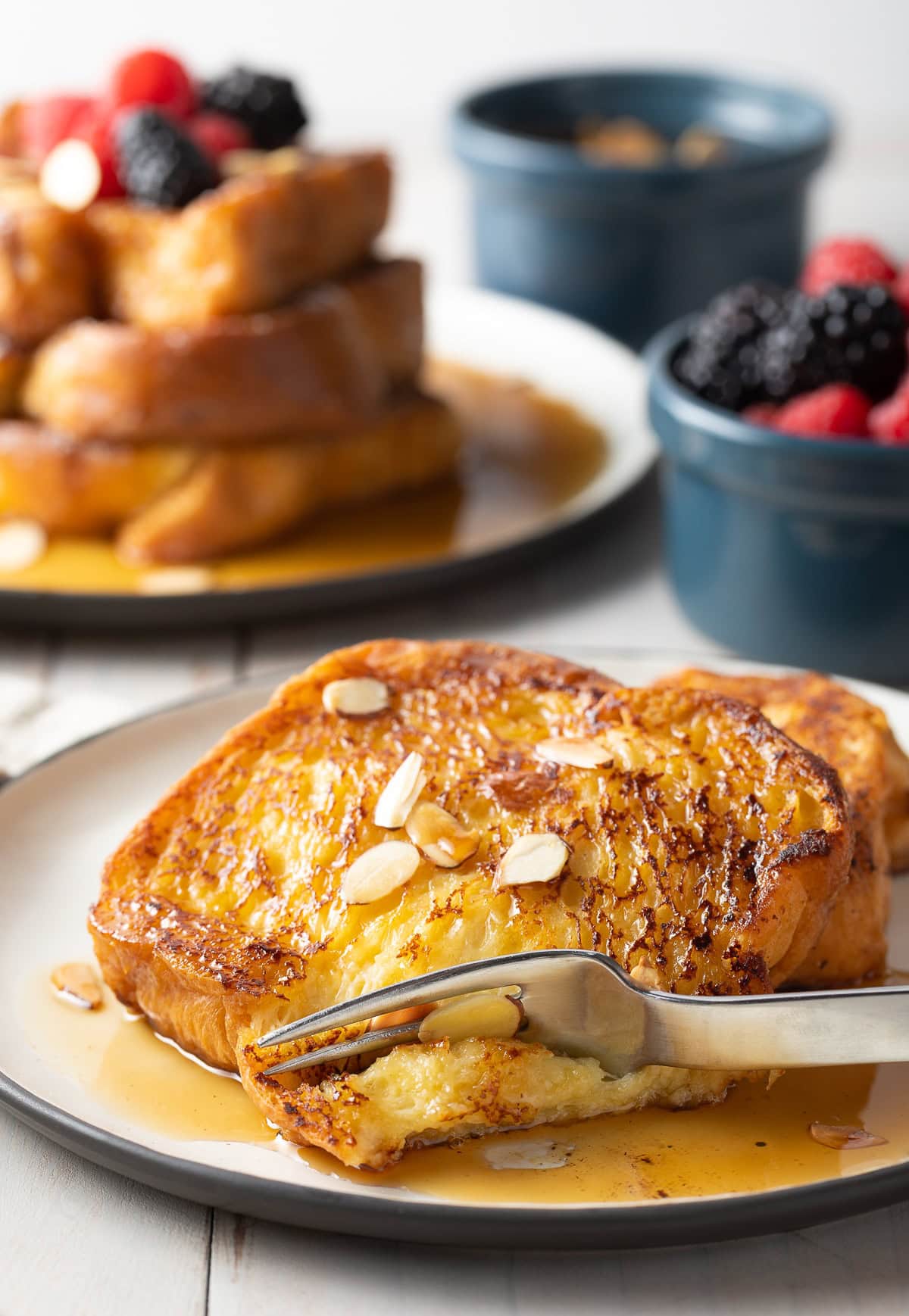 Fork taking a bite out of French toast. 