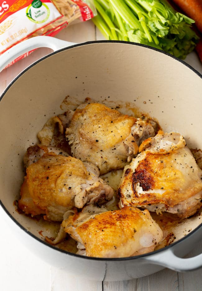 browned chicken thighs in the pot