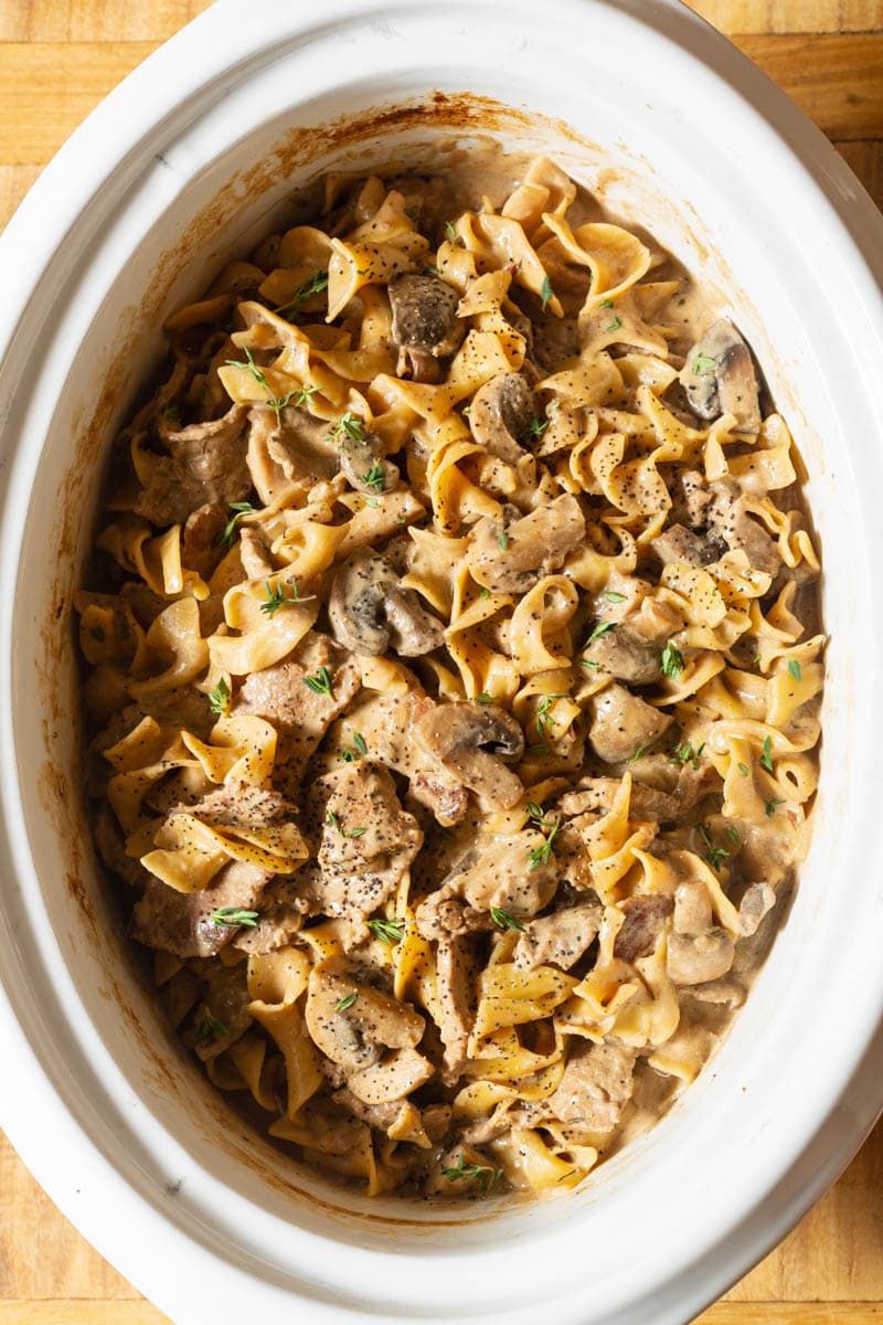 Crockpot Beef Stroganoff #ASpicyPerspective #Beef #Stroganoff #BeefStroganoff #BeefStroganoffRecipe #SlowCookerBeefStroganoff #BeefStroganoffCrockpot #SlowCooker #Crockpot Beef Stroganoff Slow Cooker Recipe in the crock with the noodles mixed in