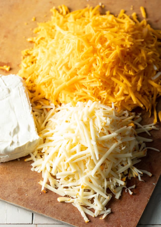 Three cheeses for the recipe - shredded sharp cheddar, shredded muenster, and block of cream cheese

