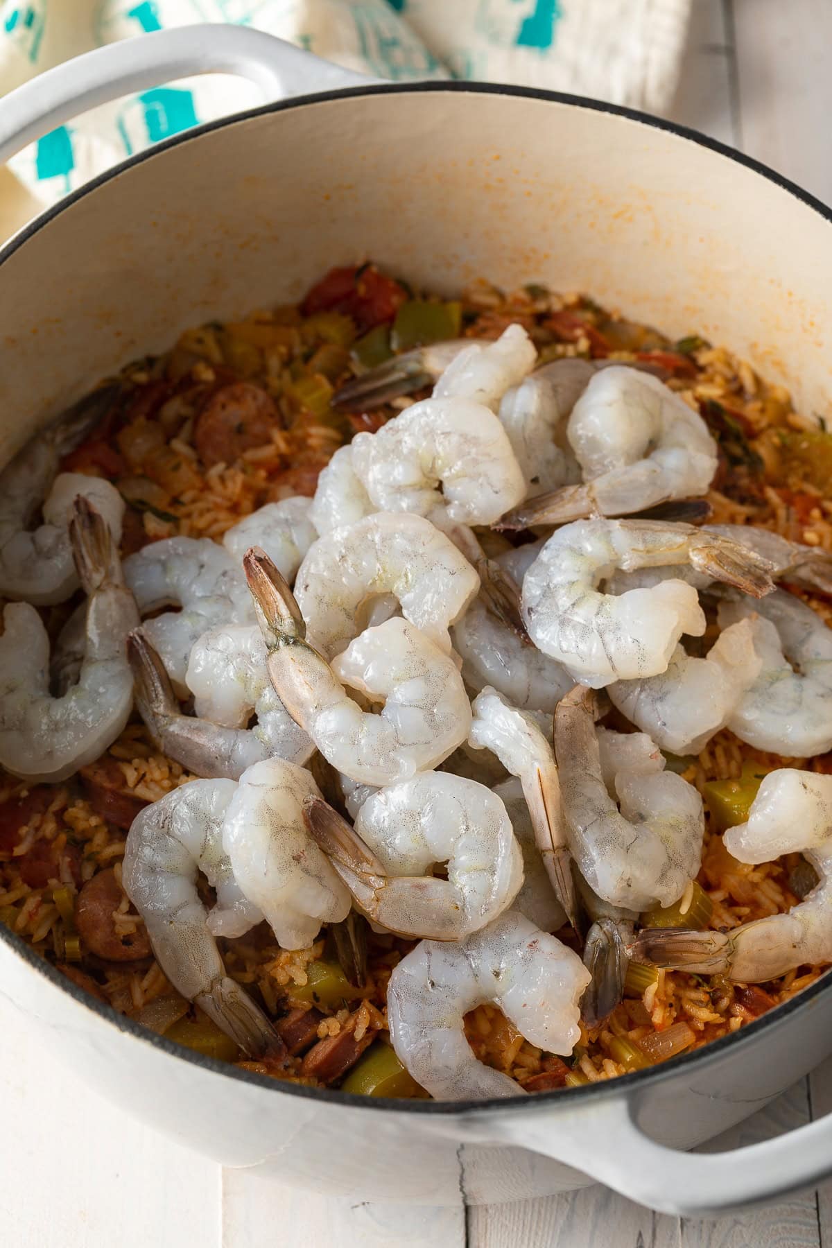 A pot of jambalaya with raw shrimp.