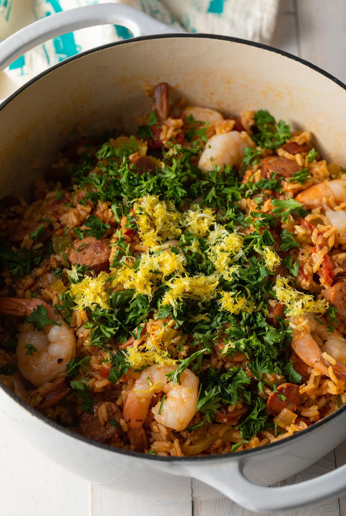 A pot of jambalaya topped with parsley and lemon zest.