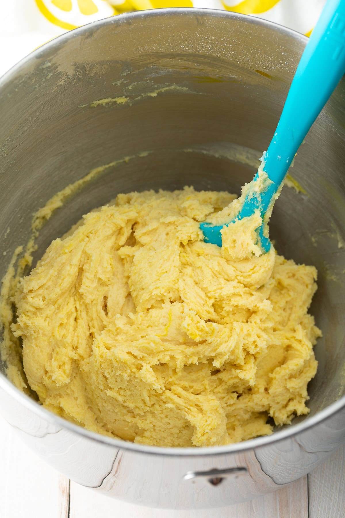 Lemon crinkle cookie dough being made in an electric mixer. 