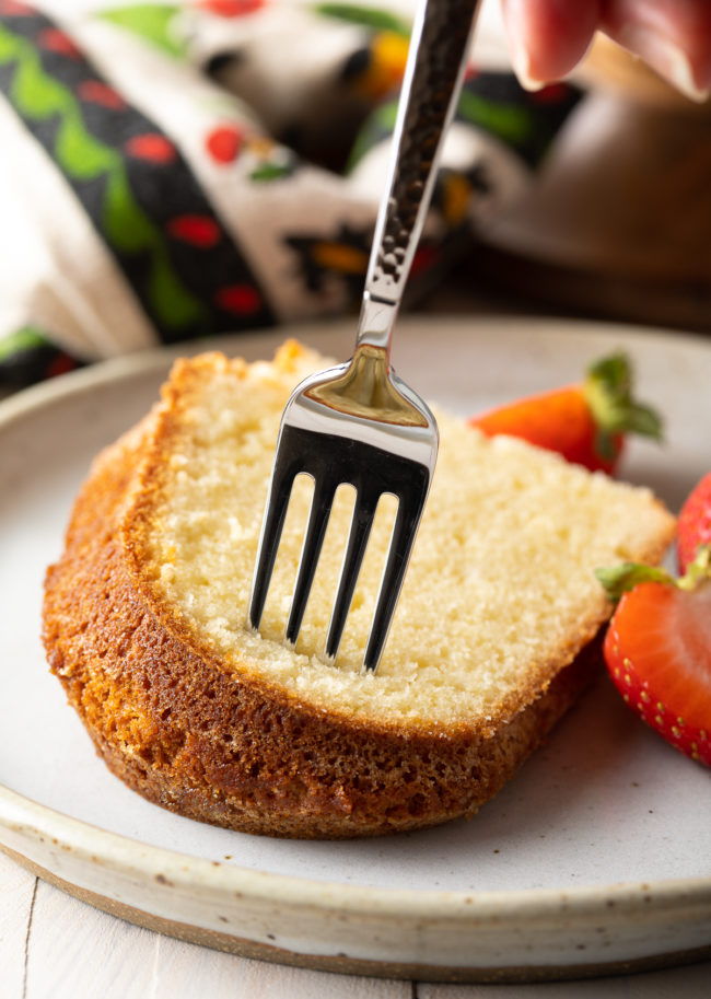 How To Make Pound Cake - Single piece on a dish with a fork inside ready for a single bite 
