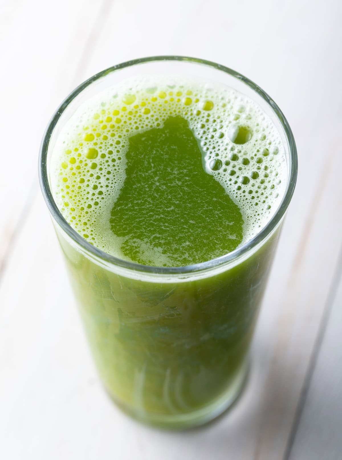 Top down view of celery juice in a glass.