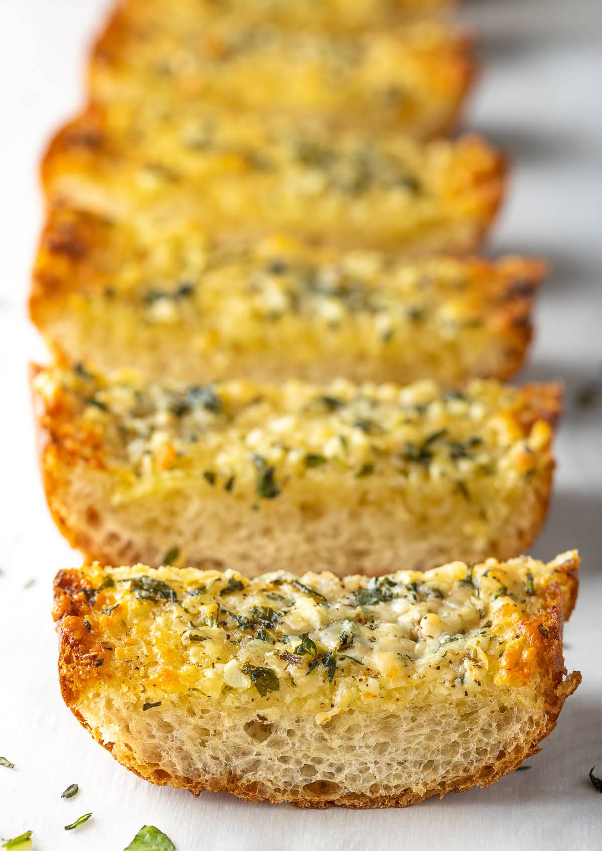 Baked garlic bread sliced into individual pieces.