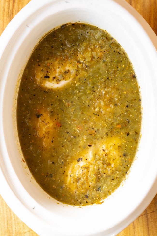 Simmered chicken in some salsa verde inside the crockpot 
