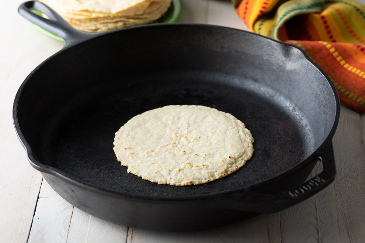 Corn tortilla cooking on a skillet. 