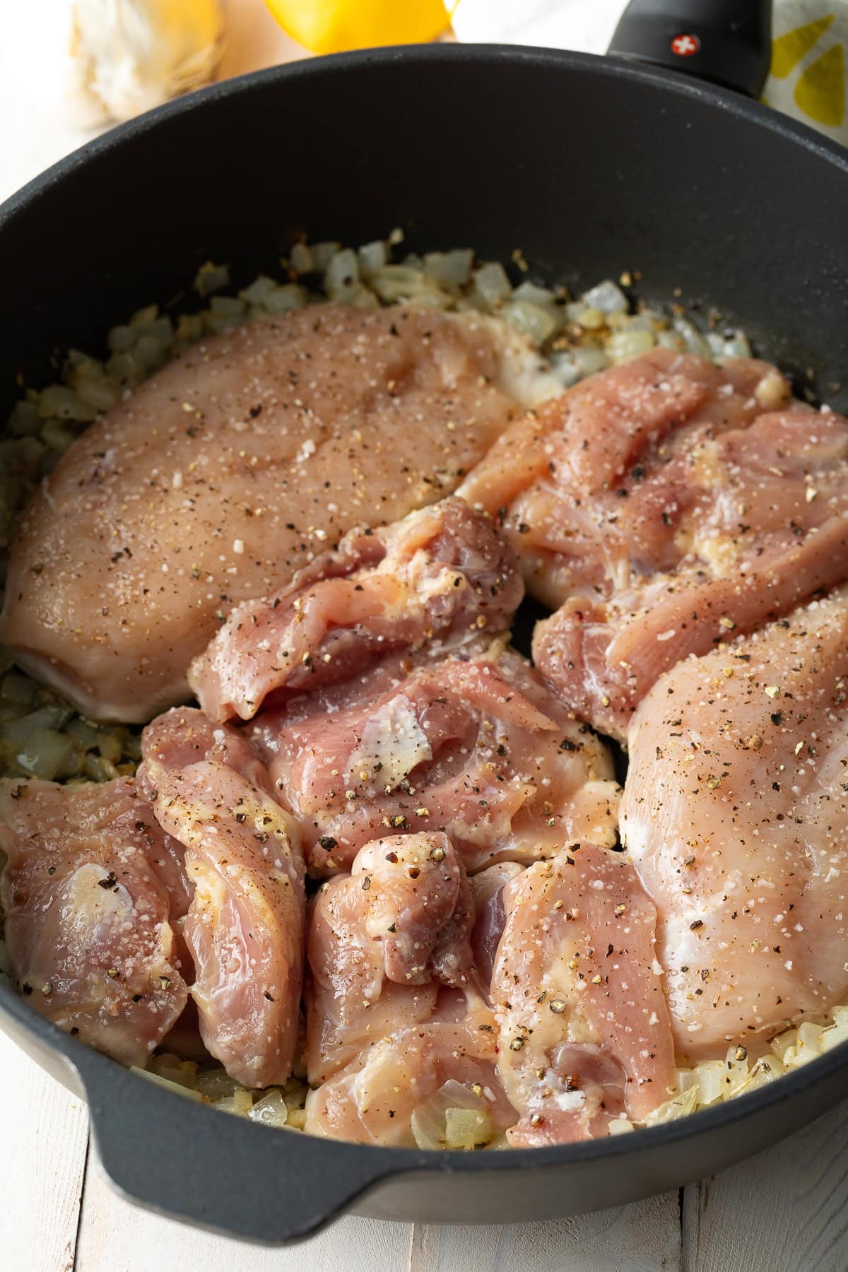 Chicken thighs cooking in a skillet.