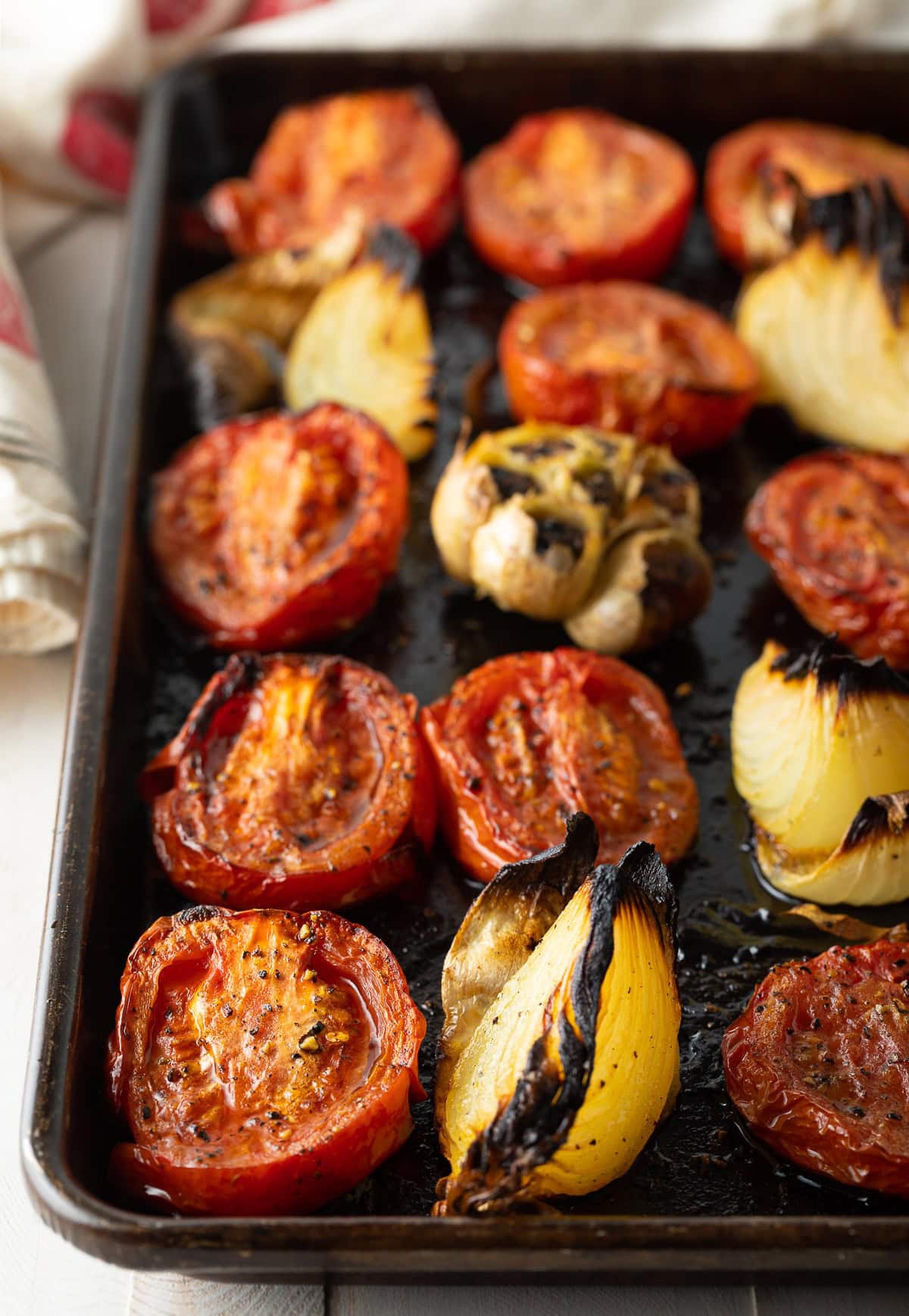 roasted tomatoes, roasted garlic, and roasted onion on a baking sheet. 