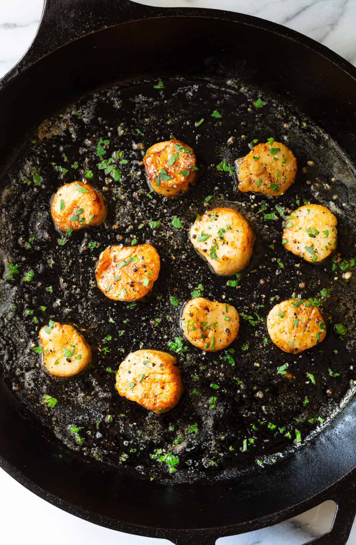 Delicious scallops cooked in garlic butter with herbs, perfect for a quick seafood dinner.