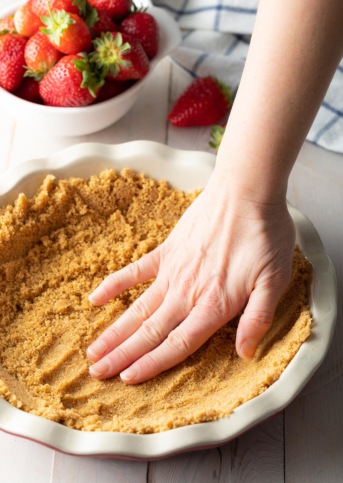Hand shaping crust onto pie pan. 