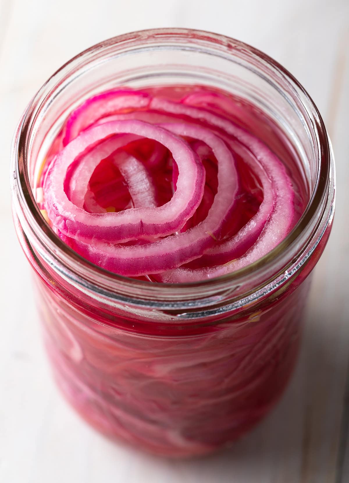 Top down view of jar filled with pickled onions.