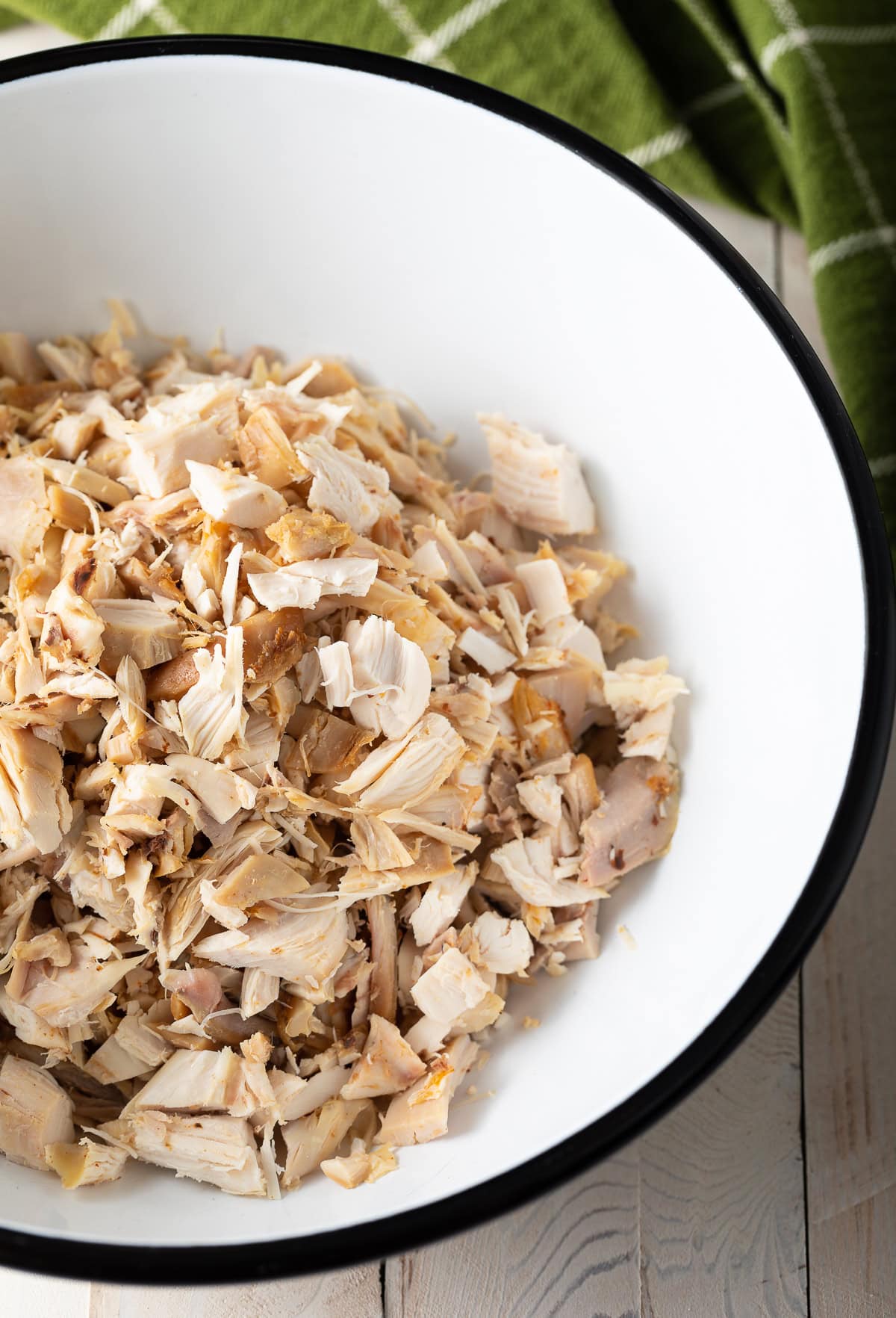 Shredded and chopped chicken in a bowl. 