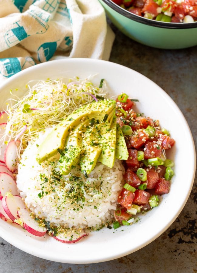 Ahi poke bowl topped with avocado and seaweed. 