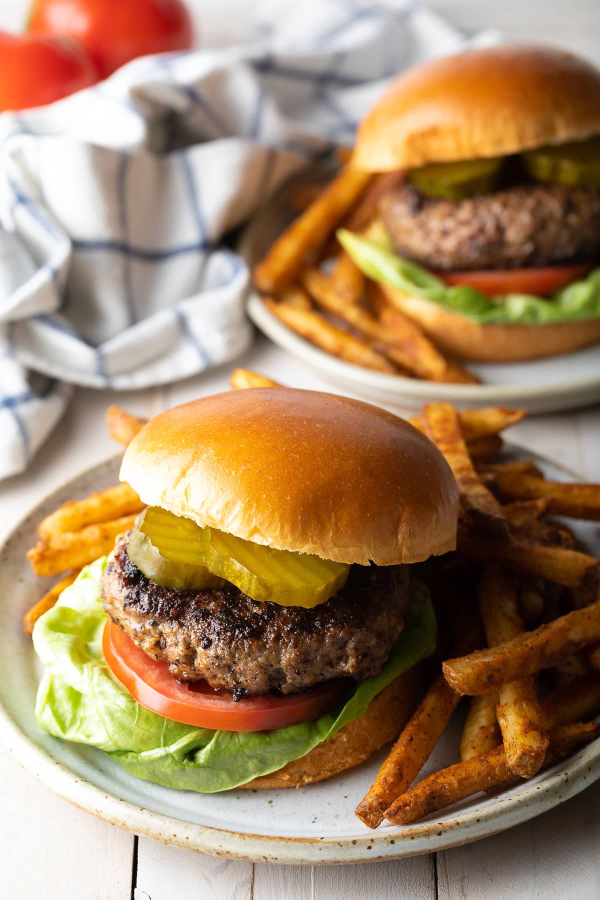Homemade burger patty recipe served with toppings and french fries. 