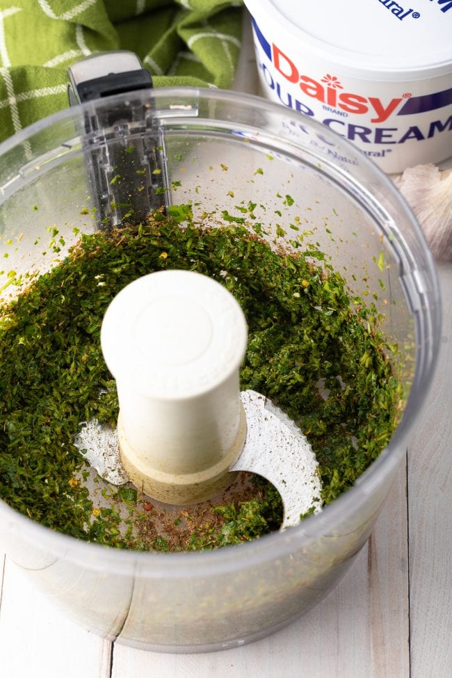 Pulsed ingredients for chimichurri in a blender.