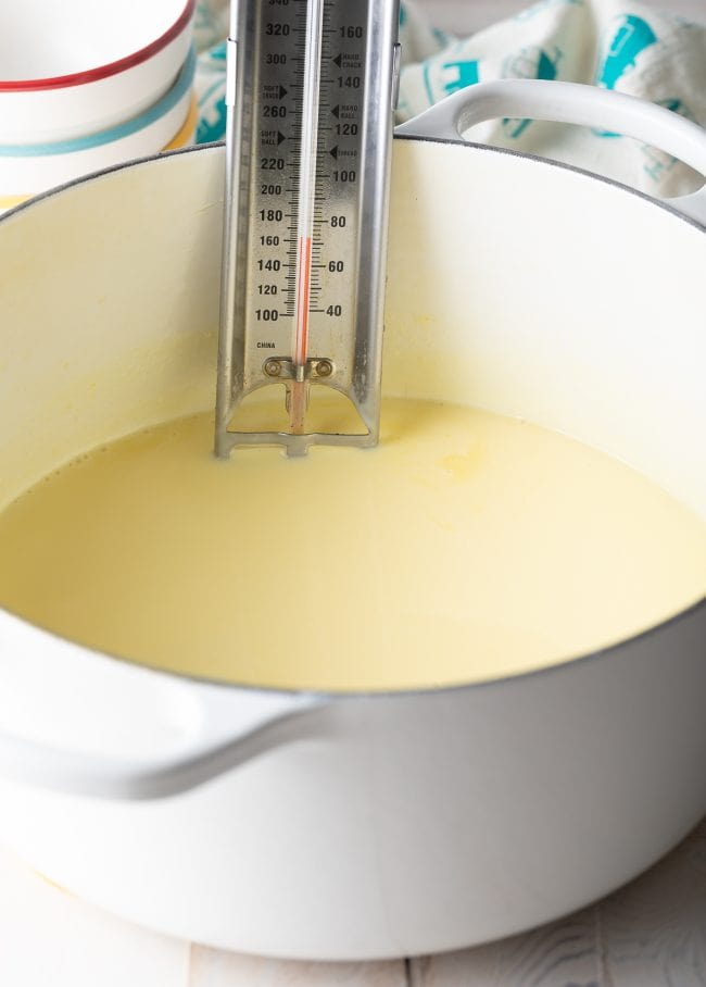 Thermometer taking temperature of egg and milk mixture.