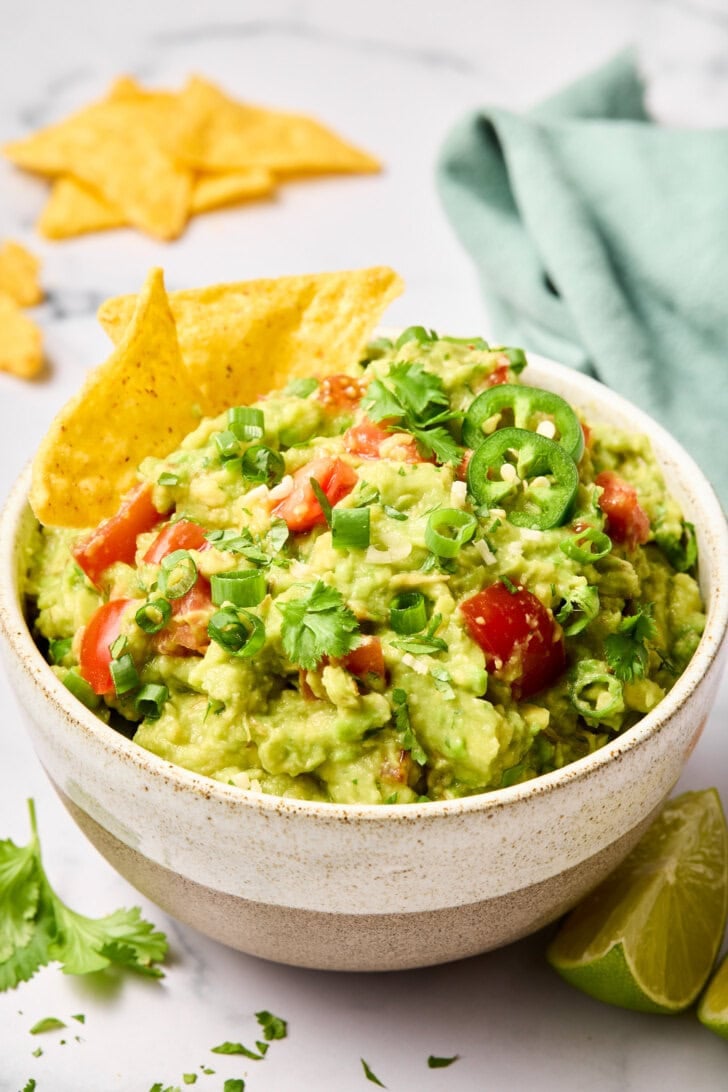 Guacamole in a bowl served with tortilla chips. 