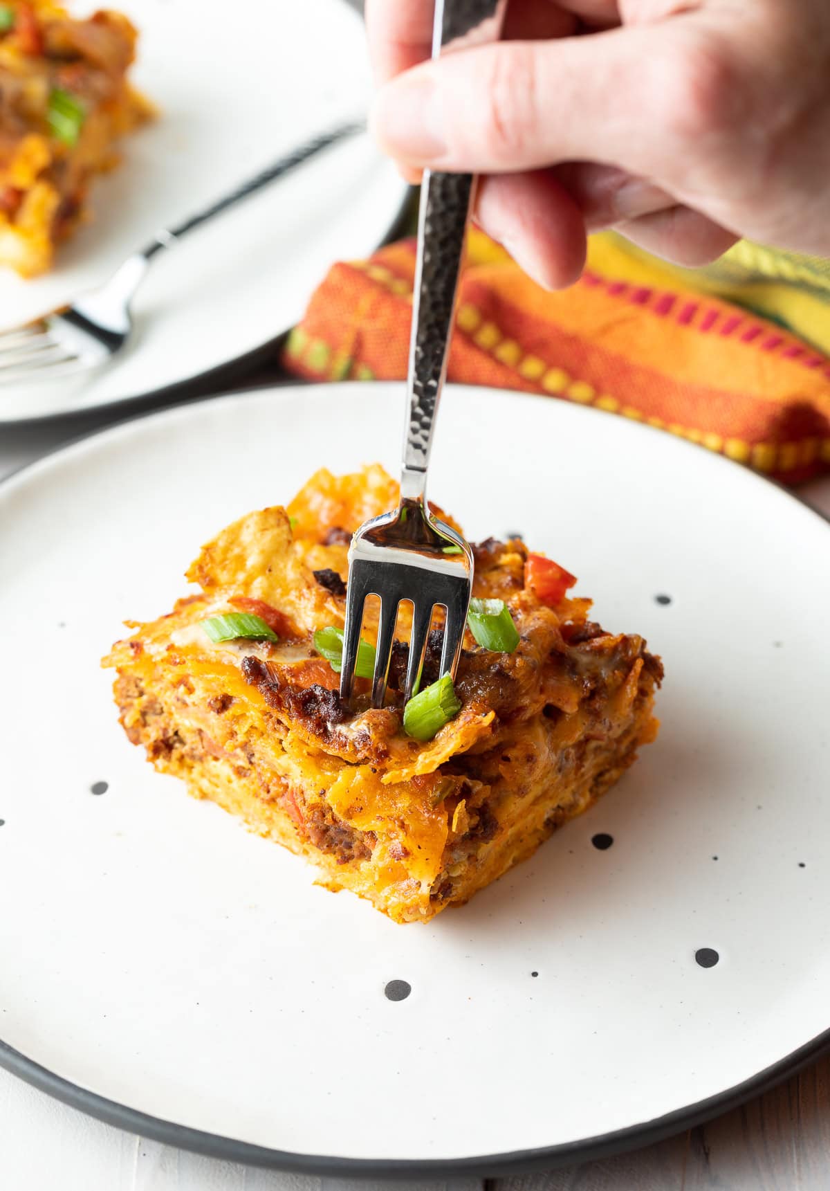 Fork taking bite out of one piece of casserole.