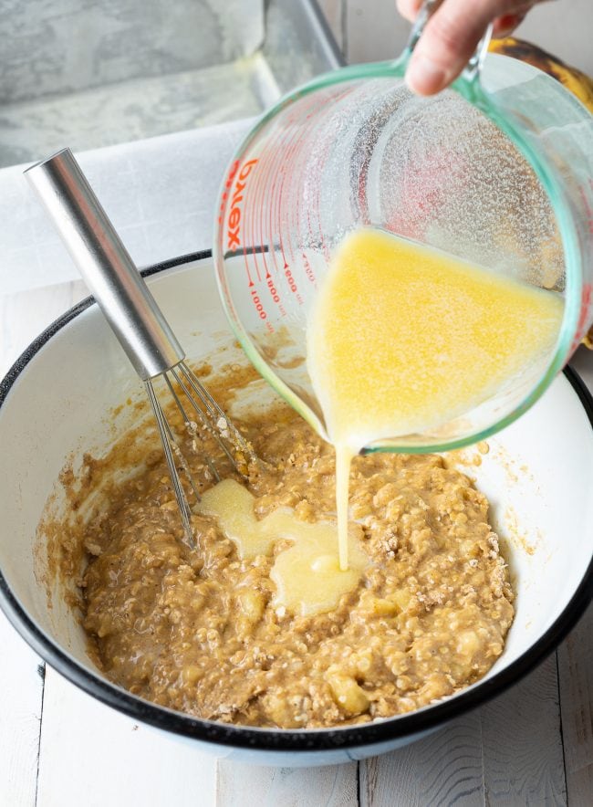Wet ingredients being poured into bowl with remainder of mixed ingredients.