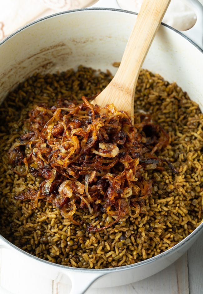 Stirring crispy fried onions into the pot of Lebanese rice.