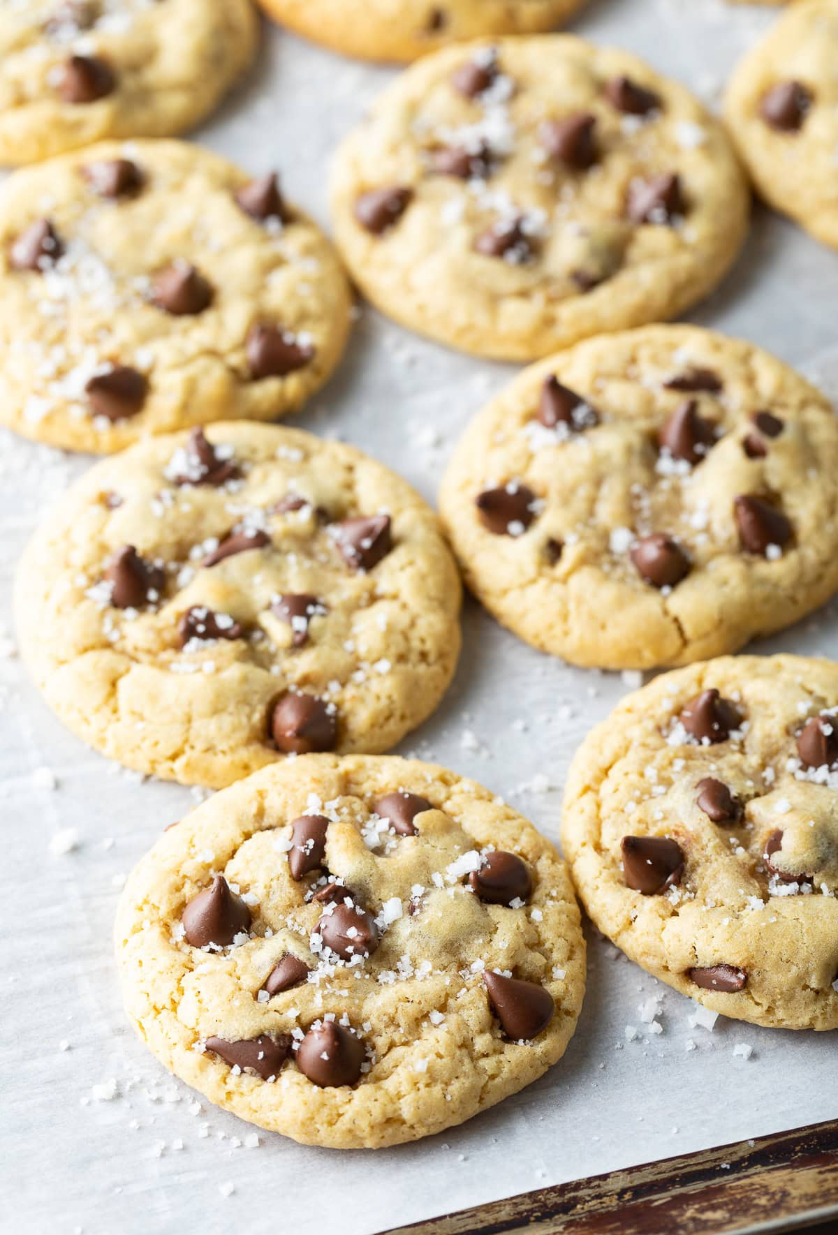 Baked salted chocolate chip cookies on a baking sheet.