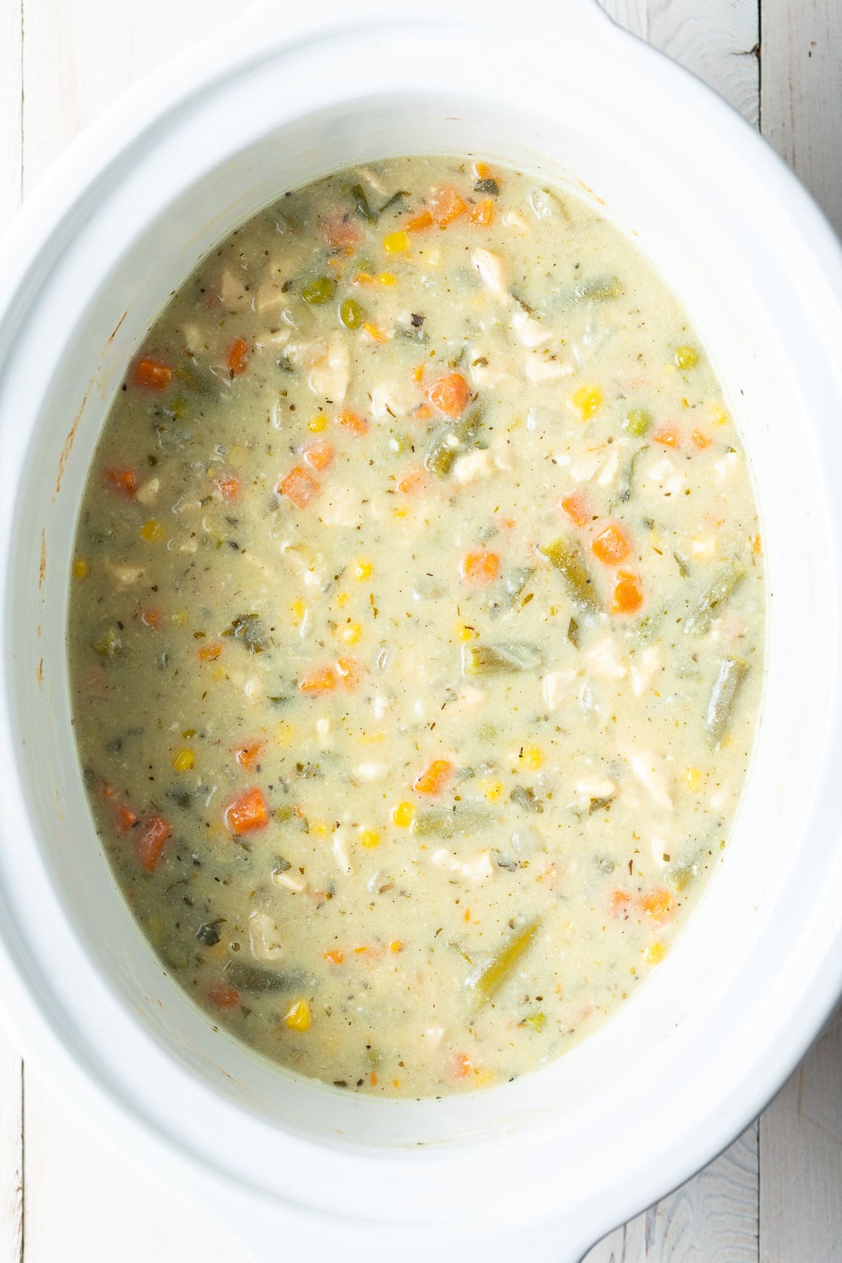 slow cooker chicken pot pie in a large white crock