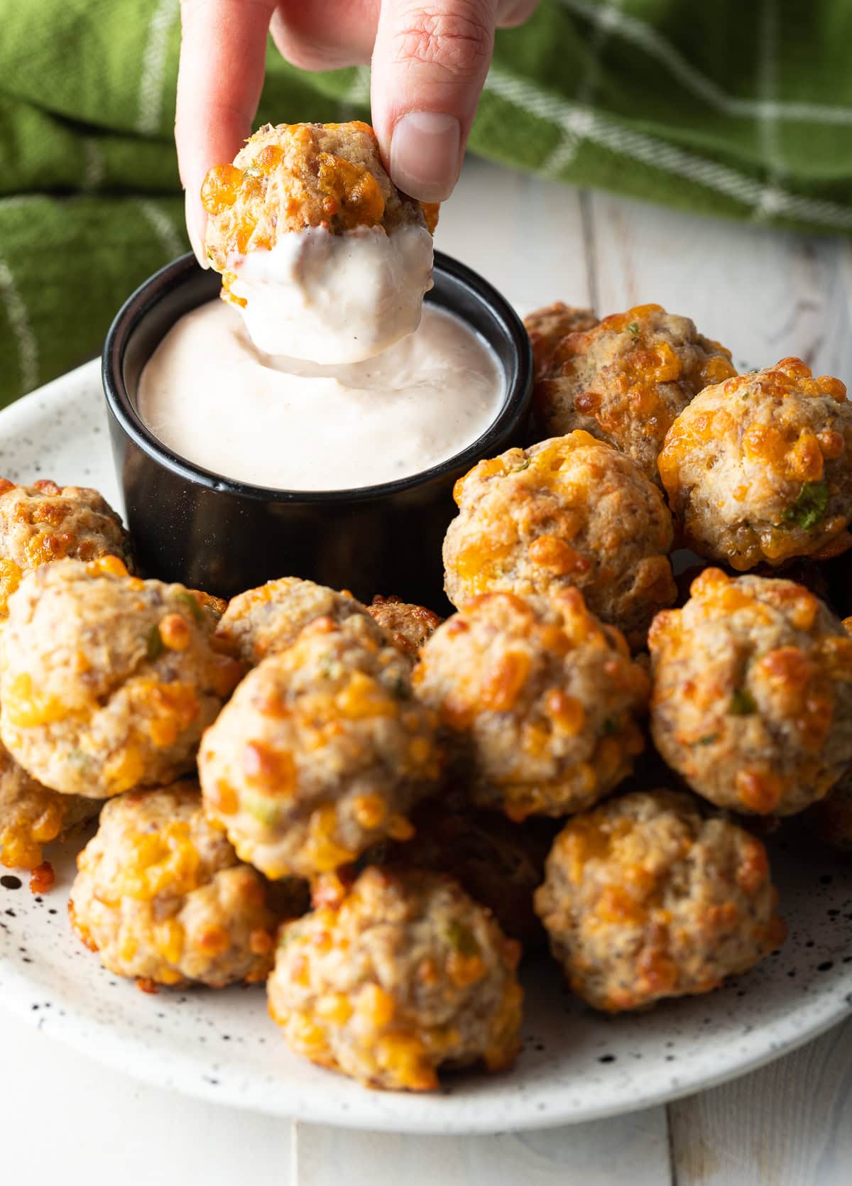 Spicy Bisquick Sausage Balls dipped in Caesar dressing