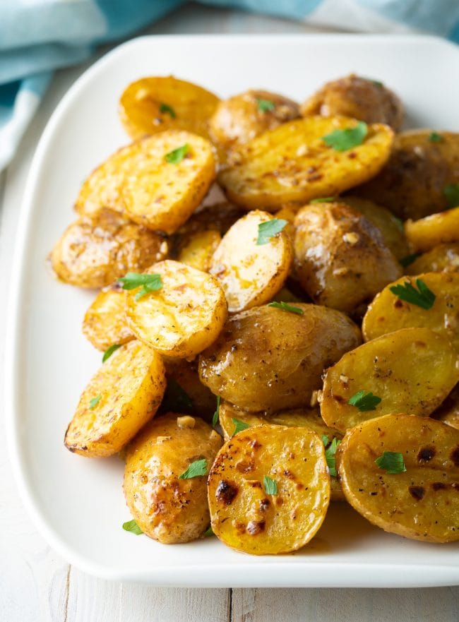 Close up of a dish of Greek lemon potatoes topped with chopped parsley.