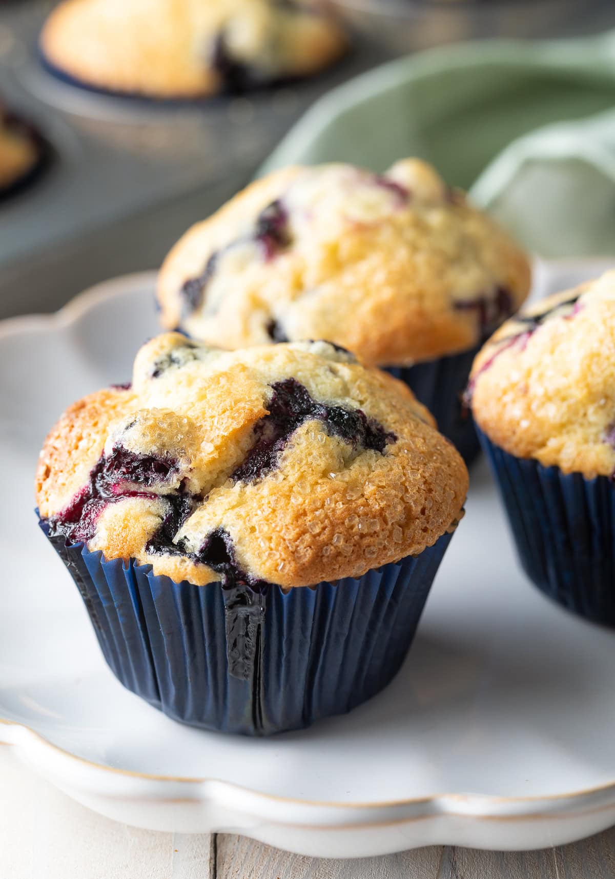 Three easy homemade blueberry muffins on a white plate.