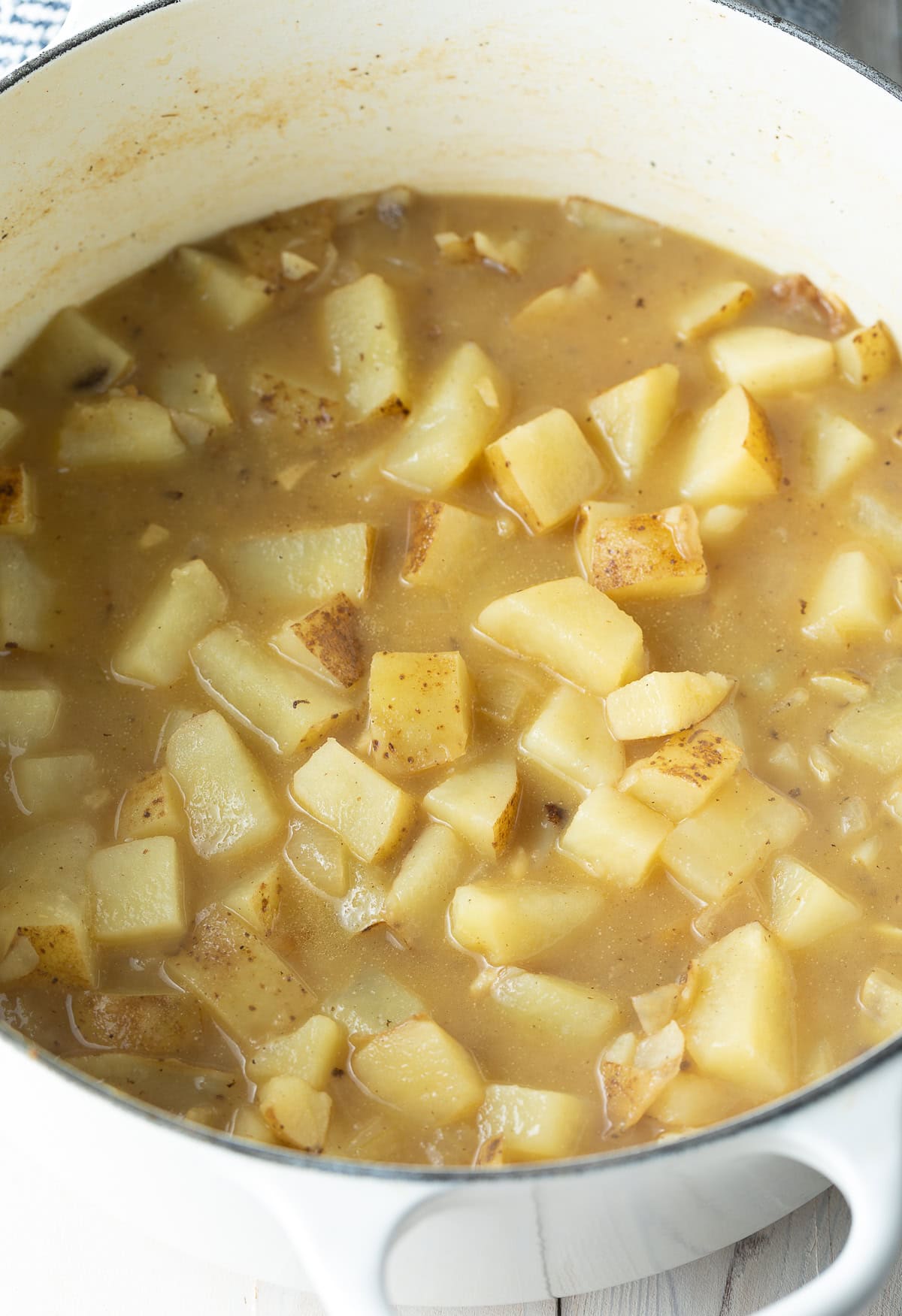 Potatoes and chicken broth in a large dutch oven.
