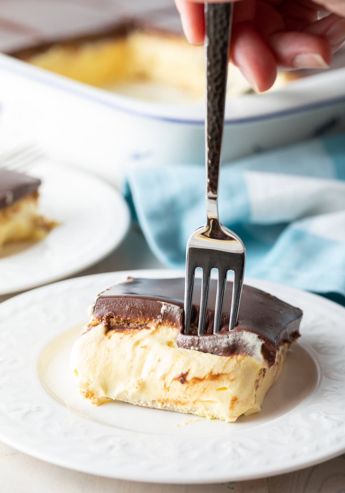 Side view of fork in a slice of eclair cake.