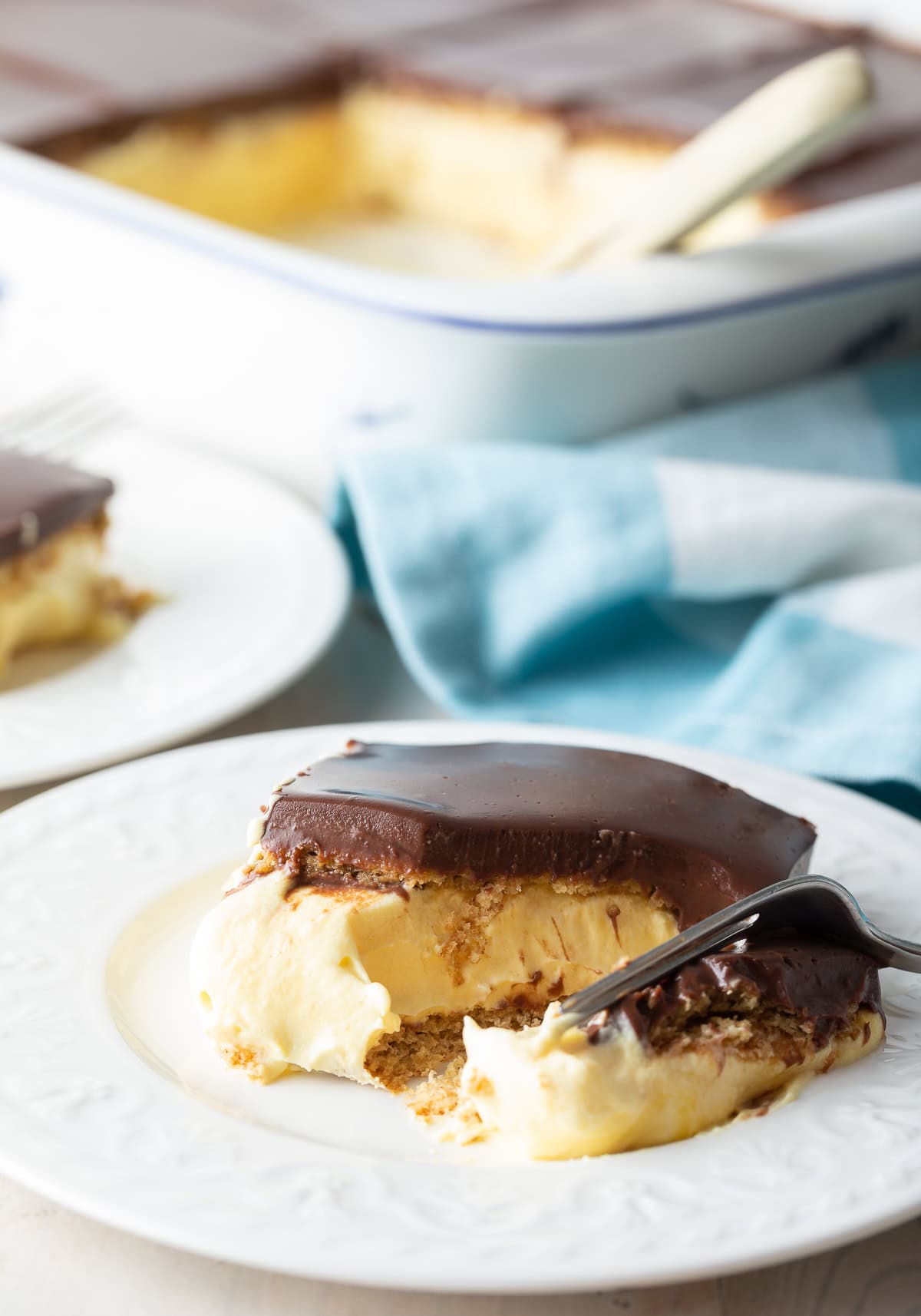 Fork removing a slice from a plated piece of eclair cake.