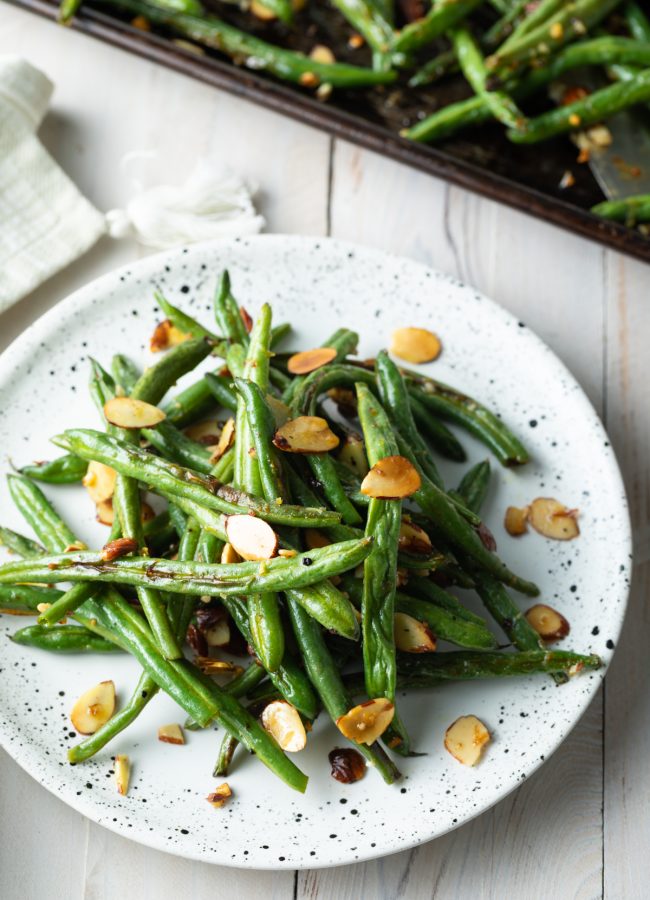 roasted green beans almondine piles on a plate