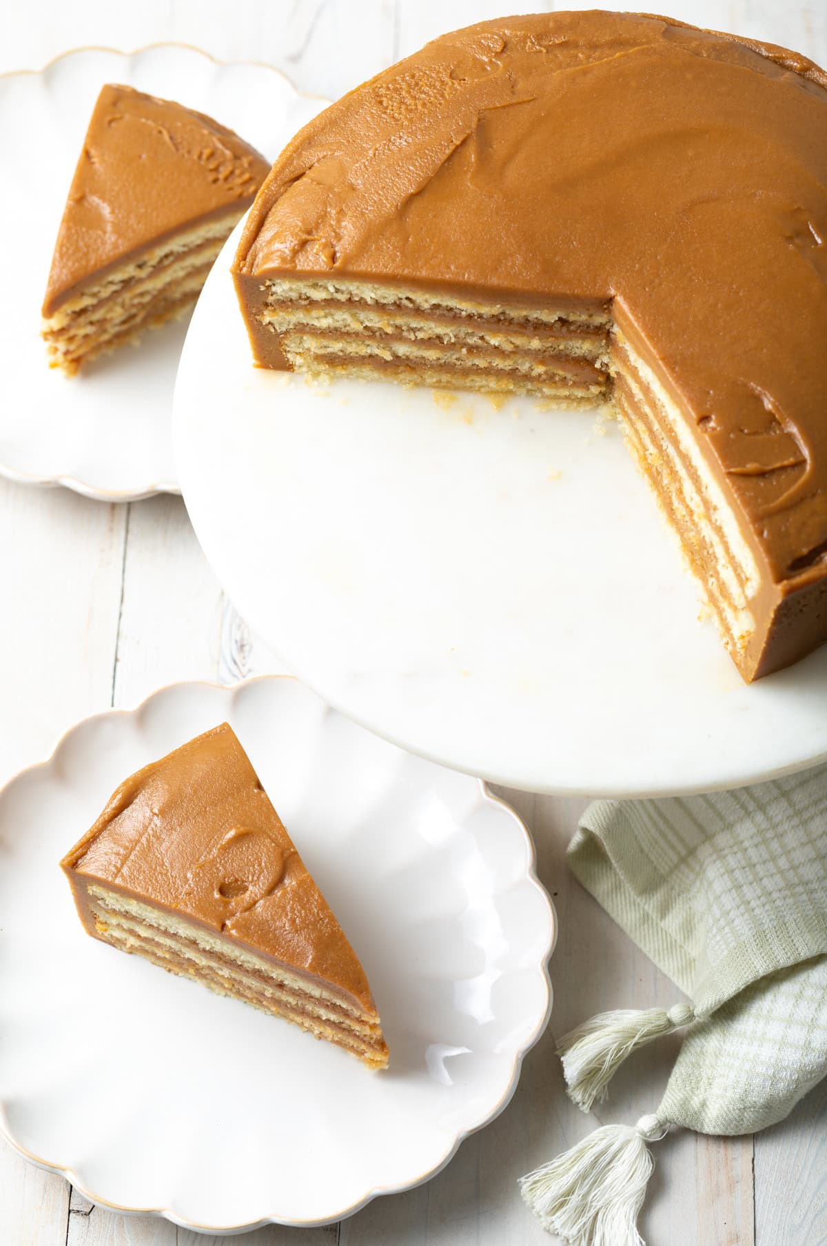 Top down view of prepped caramel cake with two slices removed and plated. 