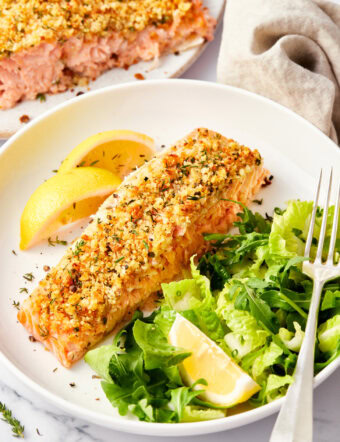 Salmon with a parmesan herb crust with a few bites missing at the end.