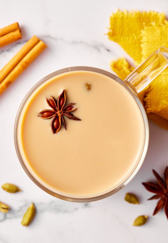 Top down view of chai tea in a mug topped with spices.