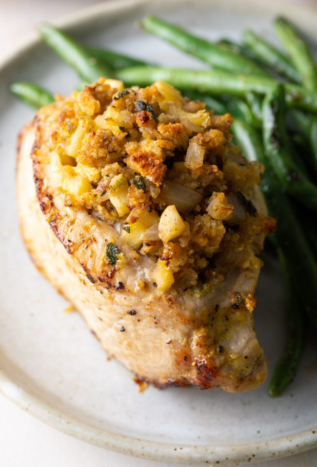 Top shot of this stuffed pork chops recipe with apple and cornbread filling and a side of green beans 

