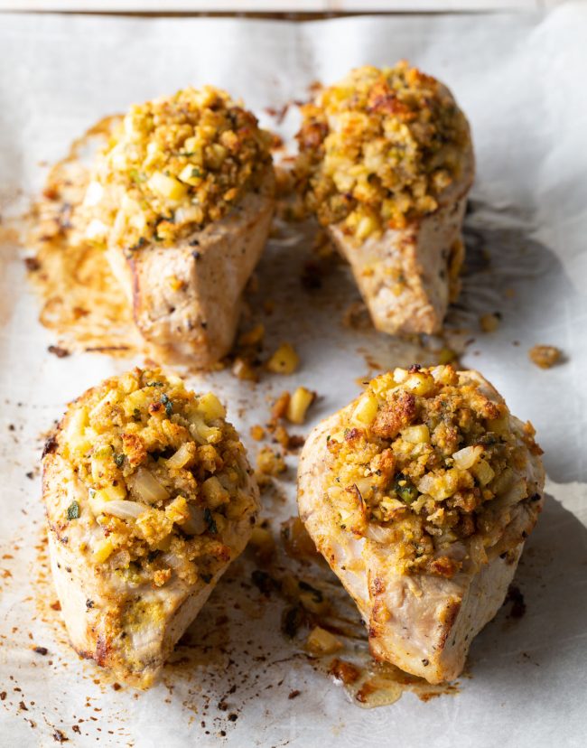 4 pieces of this stuffed pork recipe on a baking sheet lined with parchment paper 

