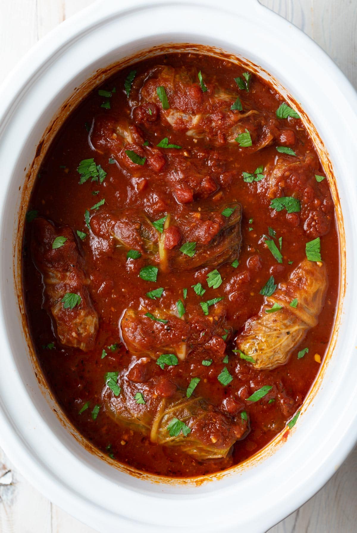Top down view of cooked golabki cabbage rolls in the slow cooker.