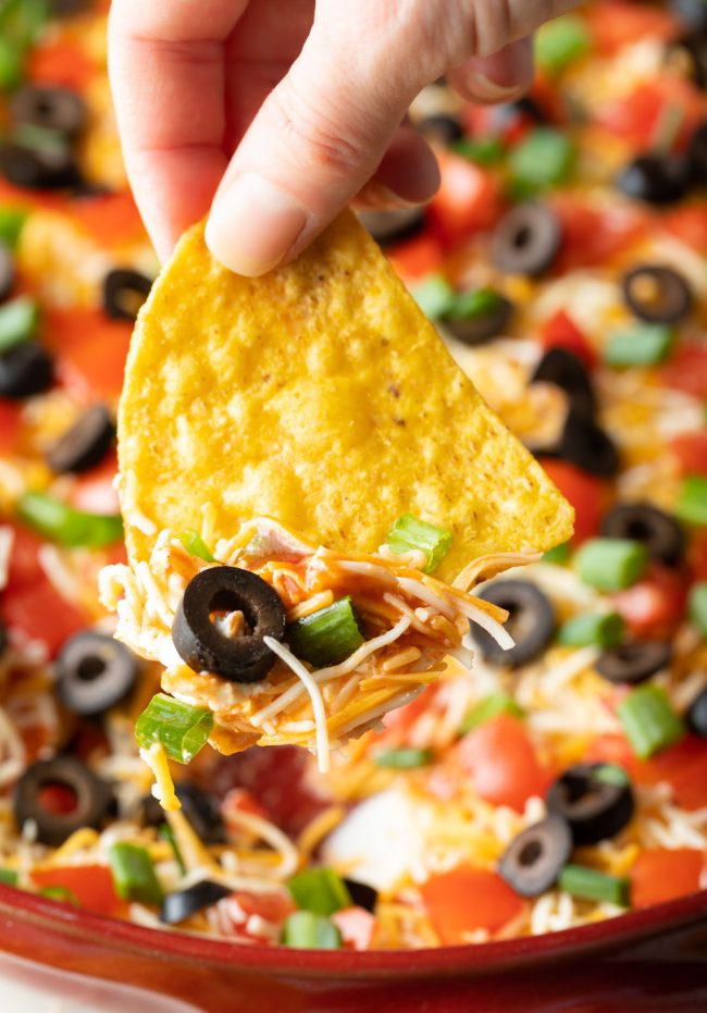 chip scooping layered taco dip