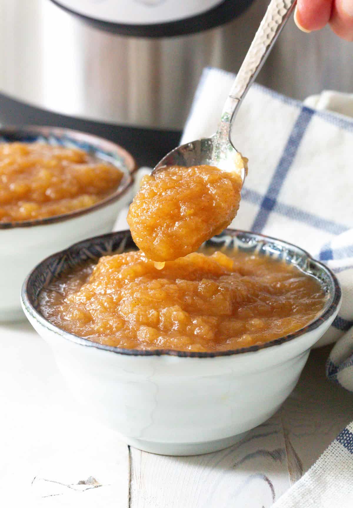 pressure cooker apple sauce recipe in small bowls - spoon lifting it up