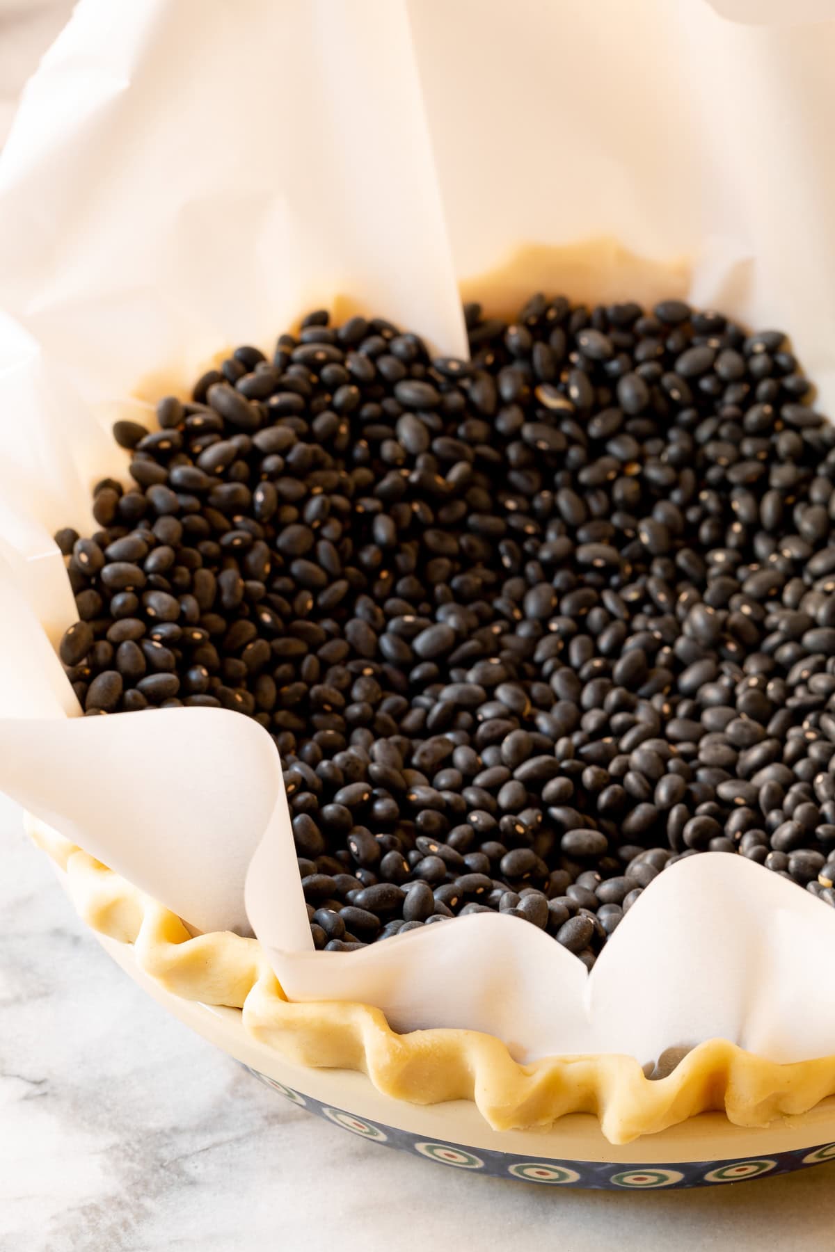 Uncooked pie crust weighed down with beans. 
