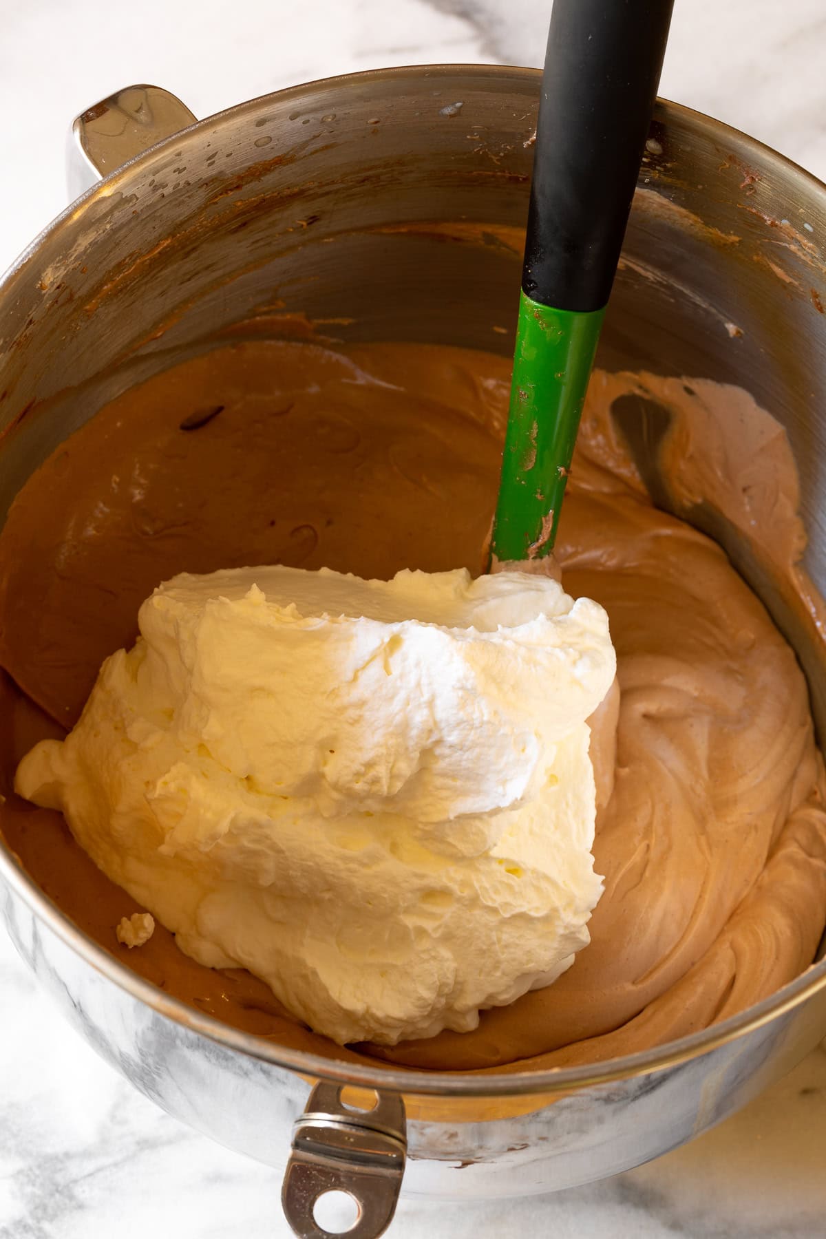 Whipped cream being folded into the chocolate filling. 