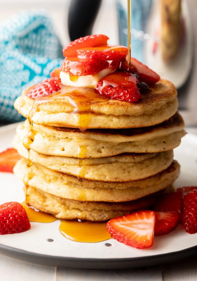 almond flour pancakes with fruit, syrup, and butter