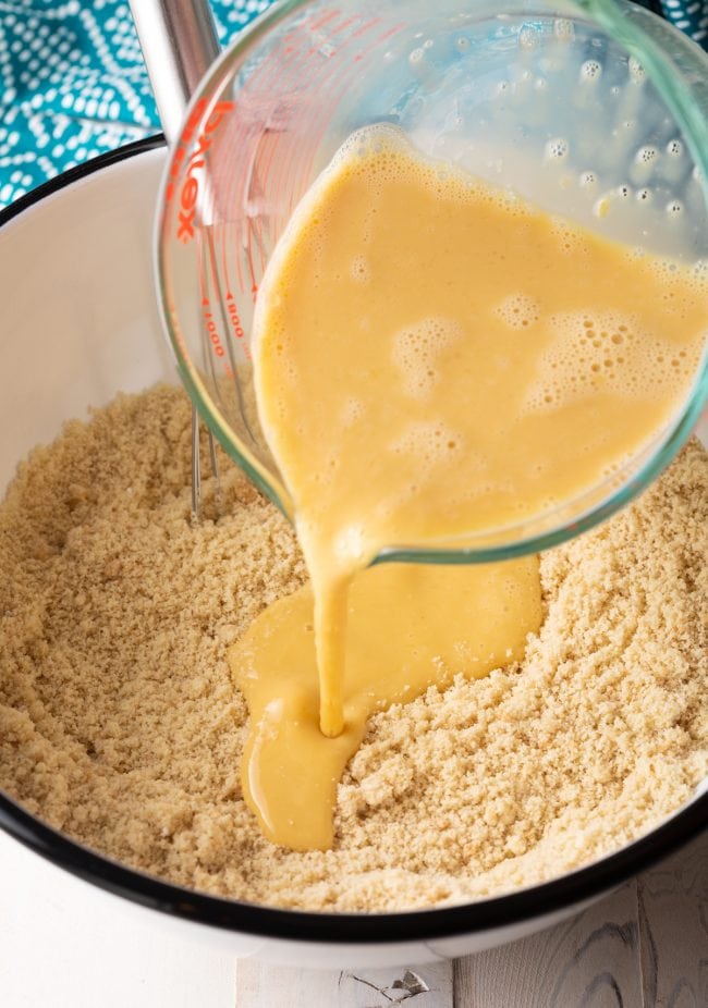 adding wet ingredients to bowl