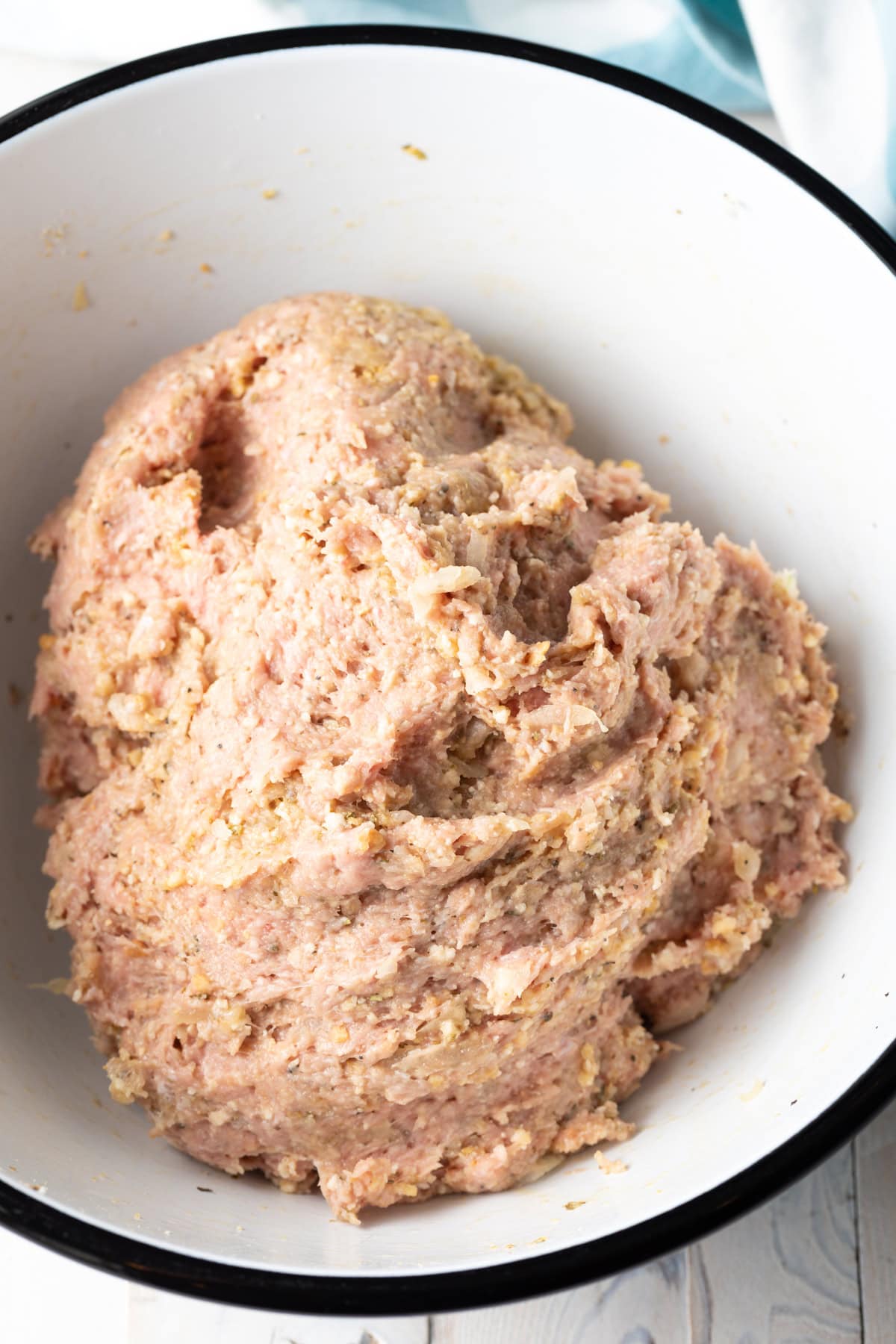Combined turkey meatball mixture in a mixxing bowl.