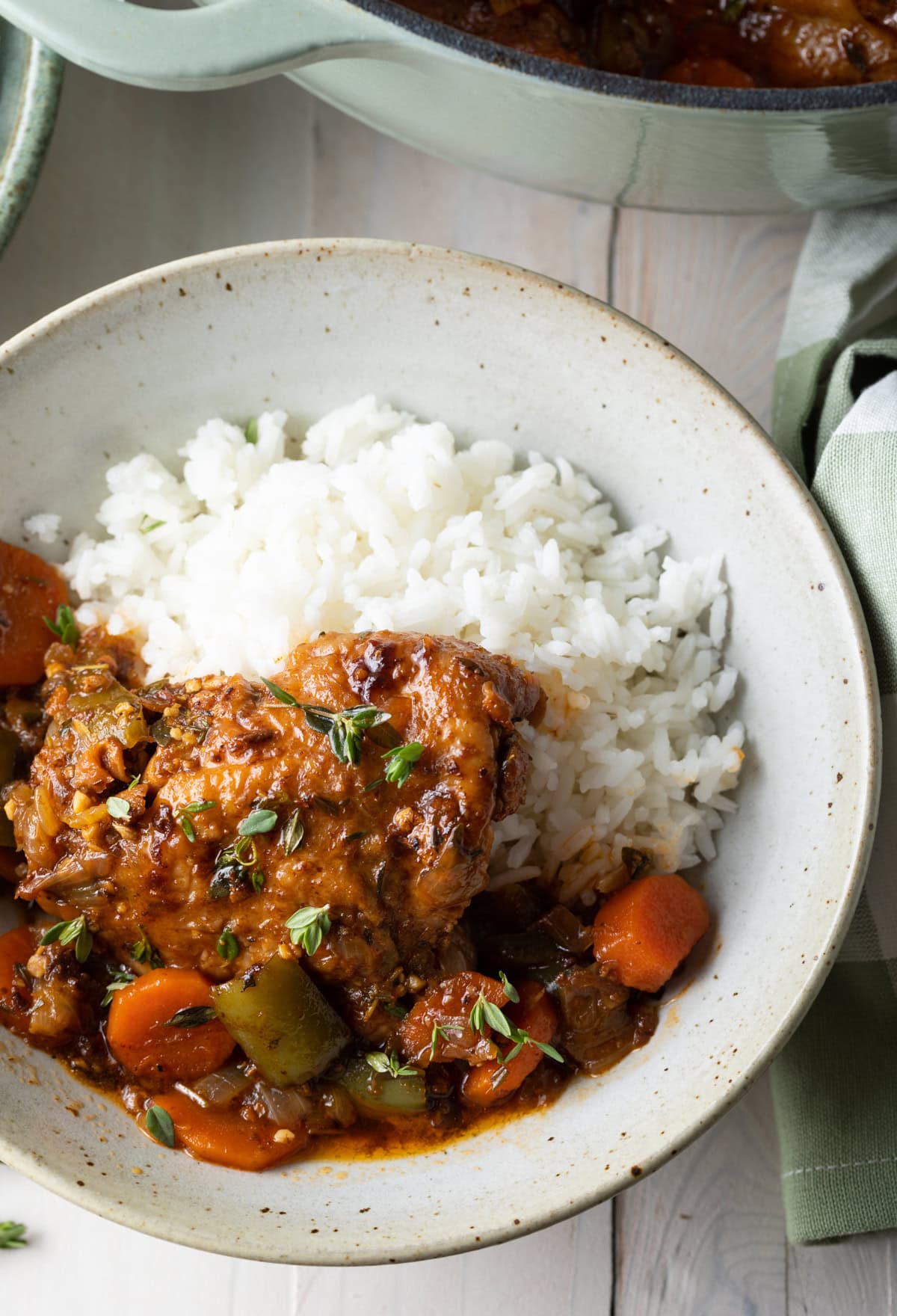 Jamaican brown stew chicken recipe with rice in a bowl