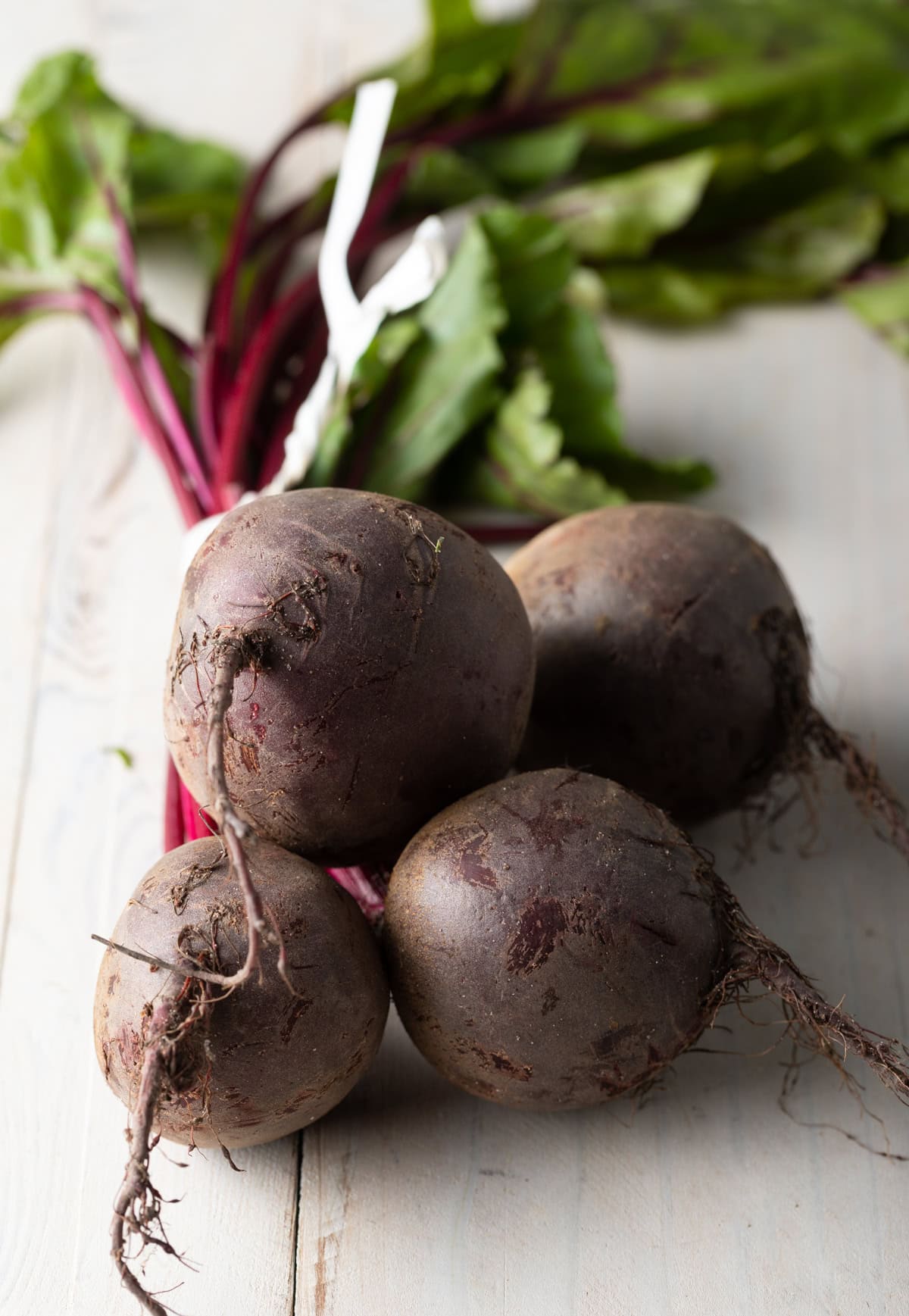 Raw unpeeled beets stacked on top of one another.